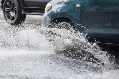 car-splashes-large-puddle-flooded-street-70286105